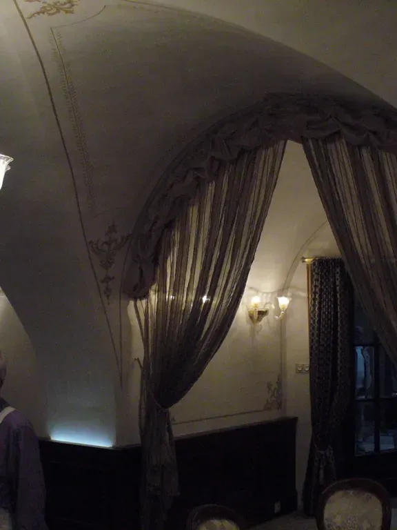 Klenutý hotelový salón s lustrom počas maliarskych prác